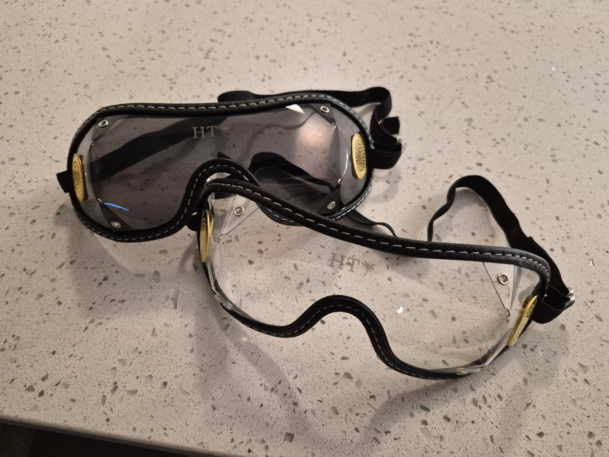 Black leather-trimmed protective eyewear with gold accents